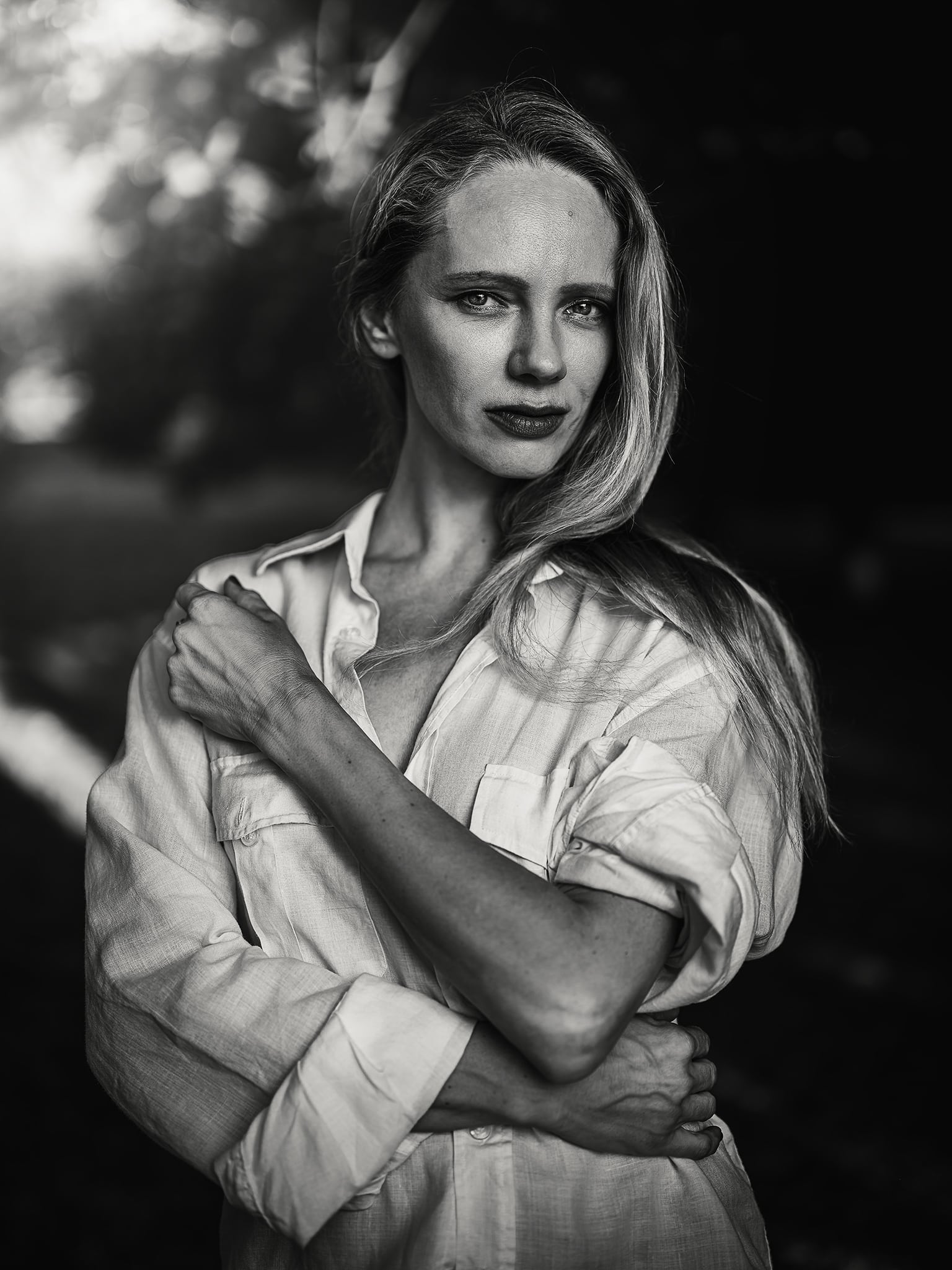 Black and white editorial portrait of a woman with soft shadows and sculptural styling