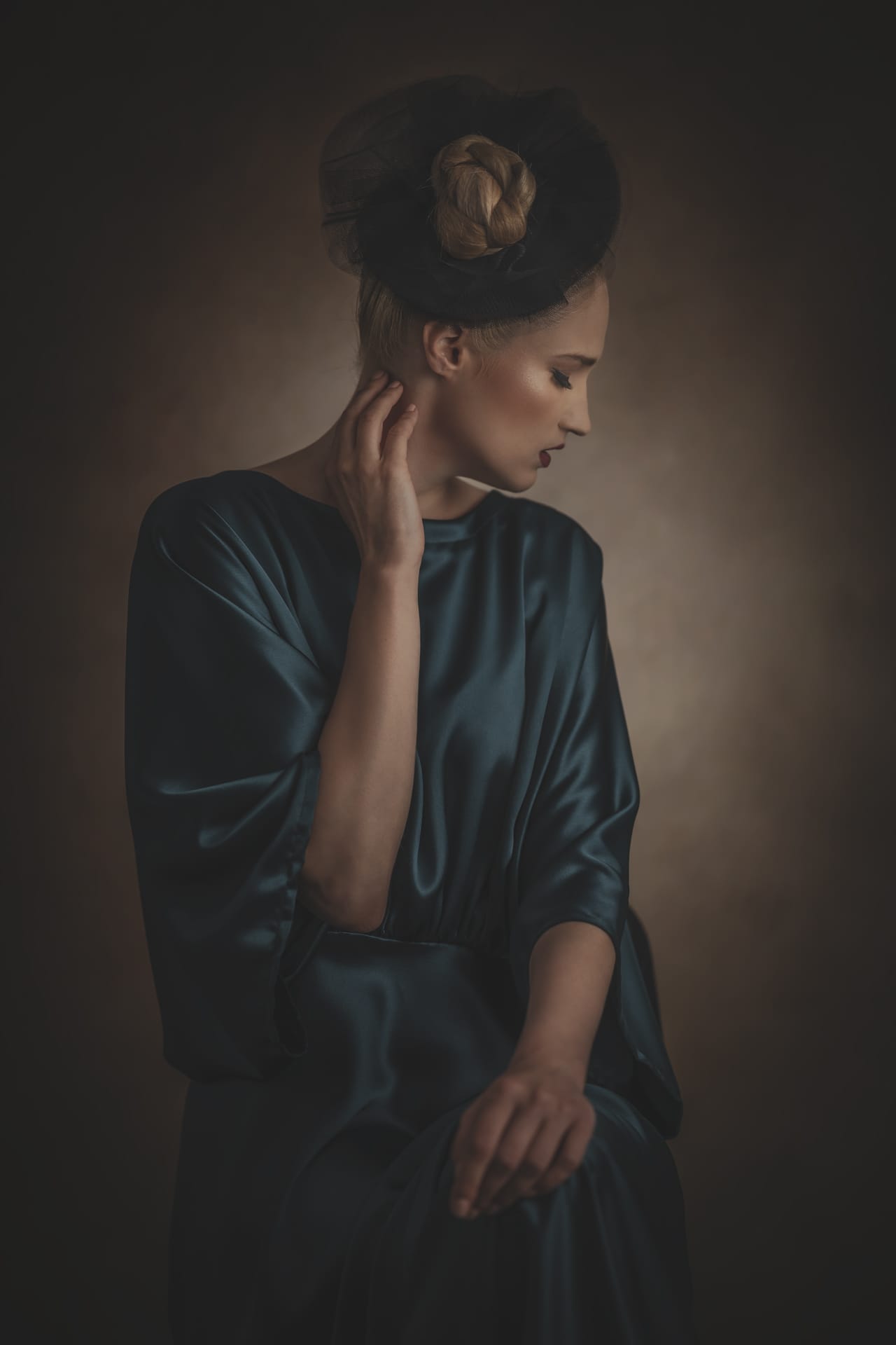 Black and white portrait of a model in a poised, elegant pose against a clean background